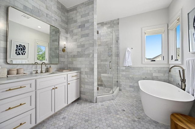 13414 Shore Vista Dr, Austin, TX 78732 - full bath with tile walls, vanity, a freestanding tub, a shower stall, and tile patterned flooring