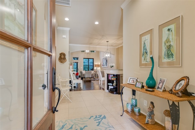 foyer entrance featuring crown molding, a notable chandelier, and light hardwood / wood-style floors