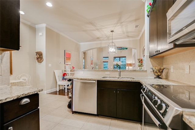 kitchen featuring appliances with stainless steel finishes, light stone counters, decorative backsplash, and sink