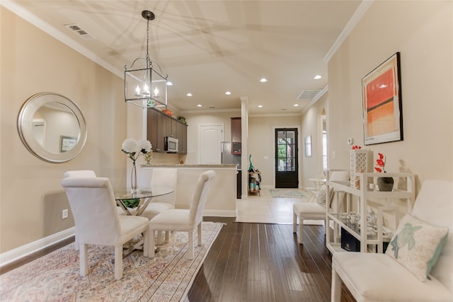 dining area featuring ornamental molding, hardwood / wood-style floors, and a chandelier