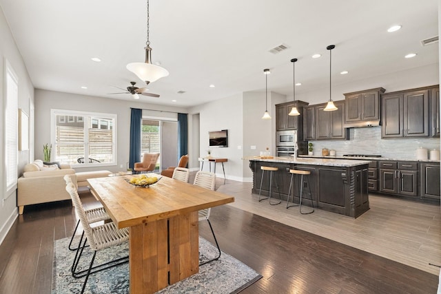 dining area featuring ceiling fan and dark hardwood / wood-style flooring