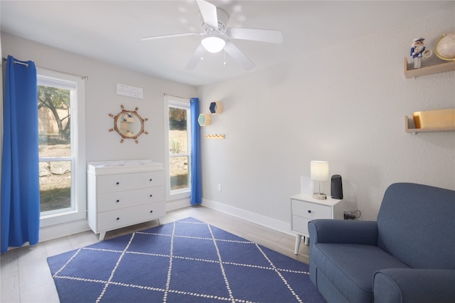 living area featuring ceiling fan and tile patterned flooring