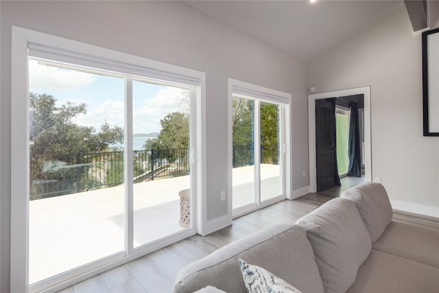 doorway featuring lofted ceiling and light hardwood / wood-style floors