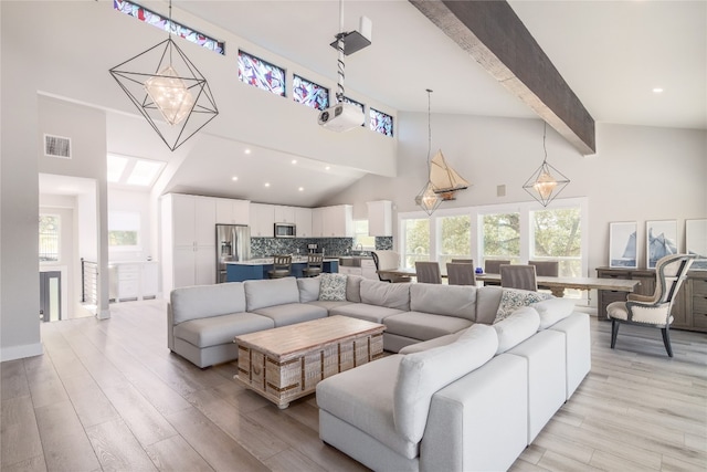 living room with beam ceiling, high vaulted ceiling, an inviting chandelier, and light hardwood / wood-style floors