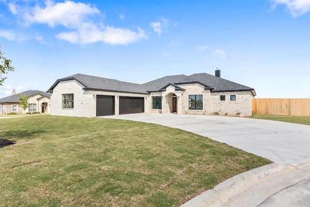 french country home featuring a front yard and a garage