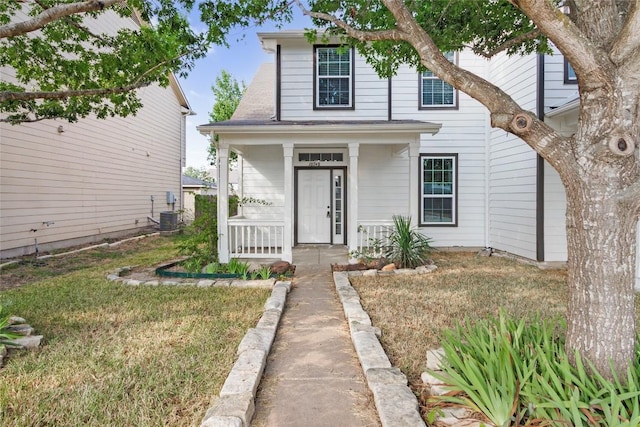 traditional-style home featuring covered porch and a front yard