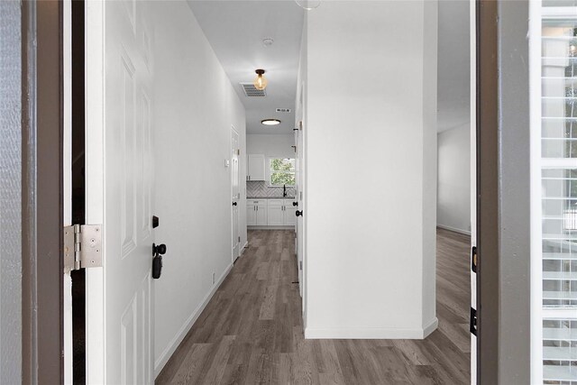 hallway featuring hardwood / wood-style floors and sink