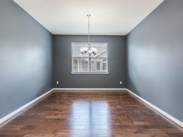 unfurnished dining area featuring dark hardwood / wood-style floors and an inviting chandelier