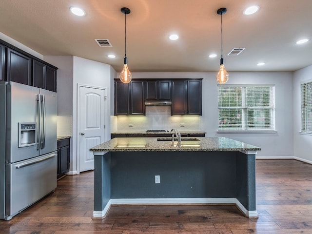 kitchen featuring appliances with stainless steel finishes, decorative backsplash, dark hardwood / wood-style flooring, and stone counters