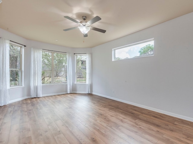 spare room featuring a healthy amount of sunlight, ceiling fan, and light hardwood / wood-style floors