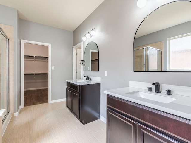 bathroom with a shower with door, vanity, and tile patterned flooring