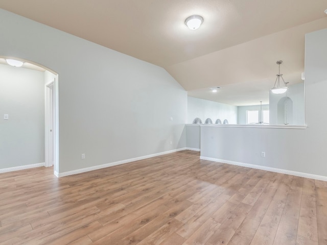 spare room with vaulted ceiling and hardwood / wood-style flooring