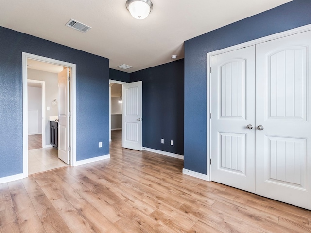 unfurnished bedroom featuring a closet and light hardwood / wood-style floors