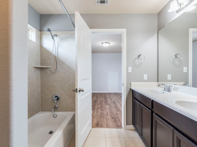 bathroom featuring hardwood / wood-style floors, tiled shower / bath, and vanity