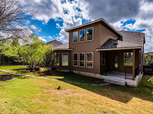 rear view of property featuring a lawn