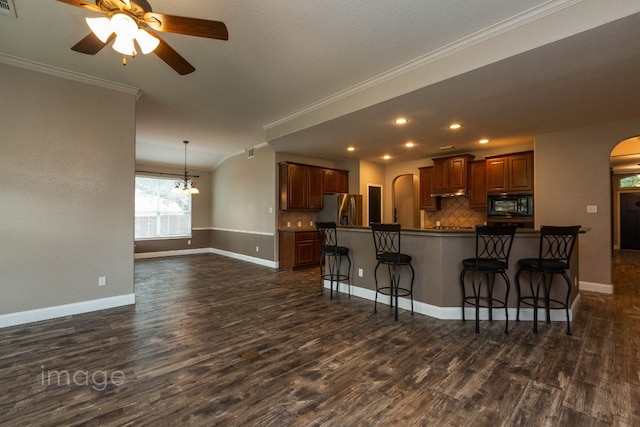 kitchen featuring black microwave, a kitchen breakfast bar, tasteful backsplash, stainless steel fridge with ice dispenser, and crown molding