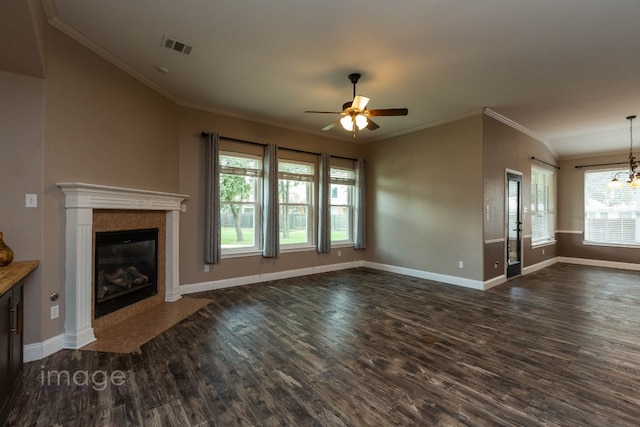 unfurnished living room featuring a tiled fireplace, crown molding, ceiling fan with notable chandelier, and dark hardwood / wood-style floors