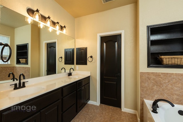 bathroom with vanity, a relaxing tiled tub, and tile patterned floors