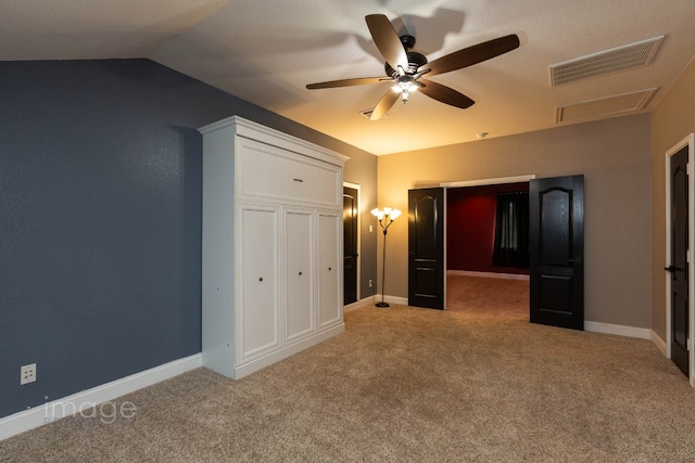 unfurnished bedroom with ceiling fan, a closet, carpet, and lofted ceiling