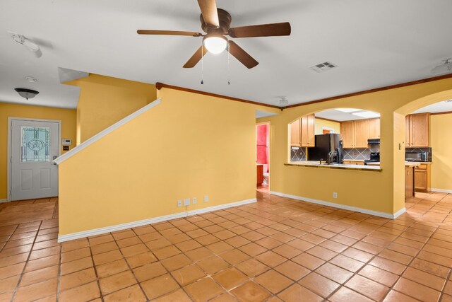 unfurnished living room with crown molding, light tile patterned floors, and ceiling fan