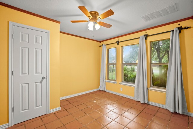 tiled empty room featuring ceiling fan and ornamental molding