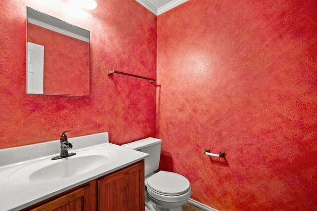 bathroom featuring toilet, ornamental molding, and vanity