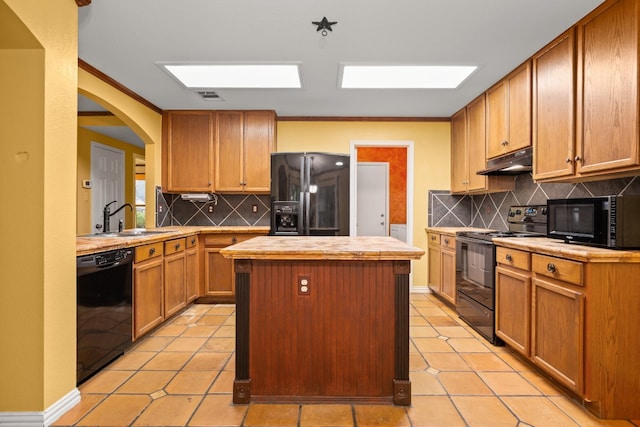 kitchen with black appliances, a kitchen island, decorative backsplash, and light tile patterned floors