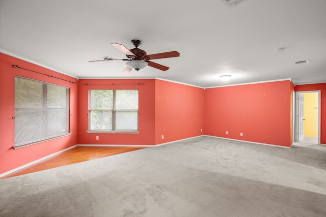 carpeted spare room featuring ceiling fan and ornamental molding