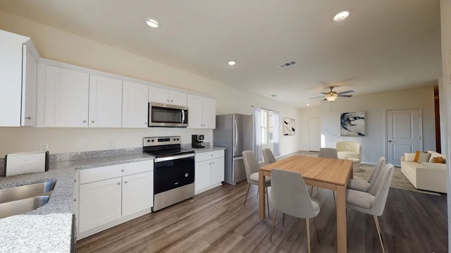 kitchen featuring white cabinetry, stainless steel appliances, hardwood / wood-style floors, and ceiling fan