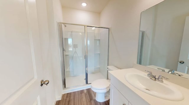 bathroom with vanity, toilet, hardwood / wood-style floors, and an enclosed shower