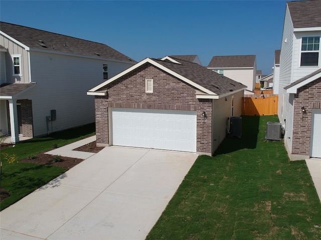 exterior space featuring a garage, a front yard, and central AC