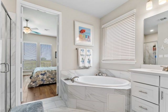 bathroom featuring vanity, hardwood / wood-style flooring, plus walk in shower, and ceiling fan