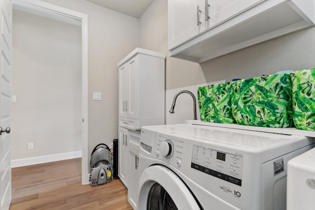 clothes washing area featuring washer and clothes dryer and light hardwood / wood-style flooring