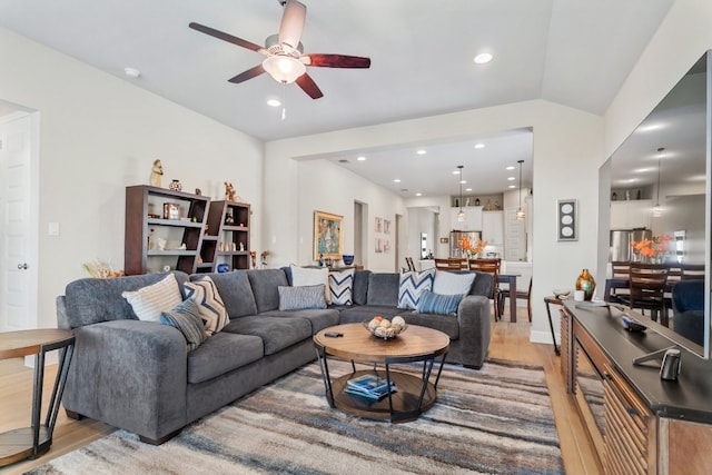 living room with lofted ceiling, ceiling fan, and hardwood / wood-style floors