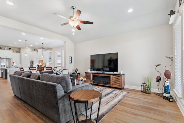 living room featuring light hardwood / wood-style flooring and ceiling fan