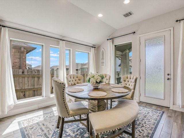 dining area featuring light hardwood / wood-style flooring and vaulted ceiling