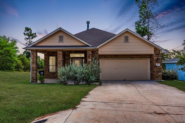 view of front facade with a lawn and a garage