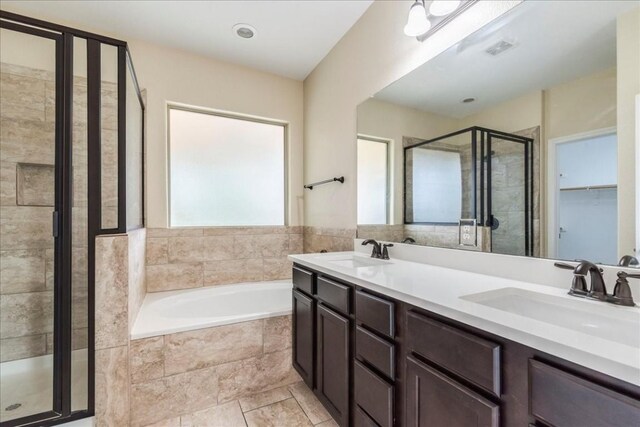 bathroom with independent shower and bath, vanity, and tile patterned floors