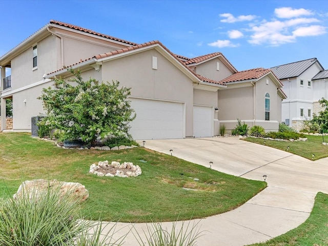 mediterranean / spanish-style house featuring an attached garage, a front yard, and stucco siding