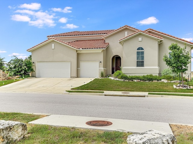 mediterranean / spanish-style home with a garage and a front lawn