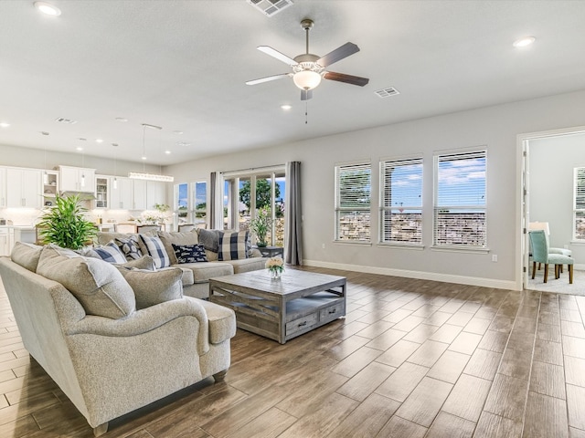 living room with dark wood-type flooring and ceiling fan