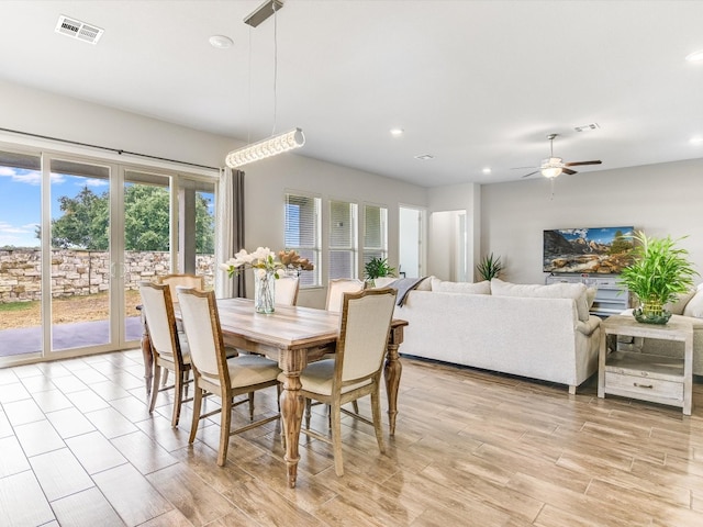 dining space with ceiling fan and light hardwood / wood-style flooring