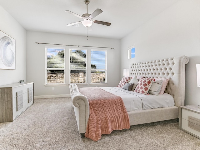 carpeted bedroom with multiple windows and ceiling fan