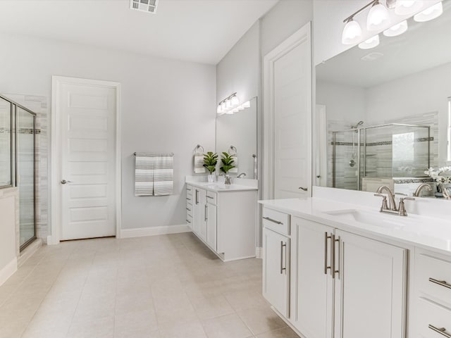 bathroom with tile patterned flooring, walk in shower, and vanity