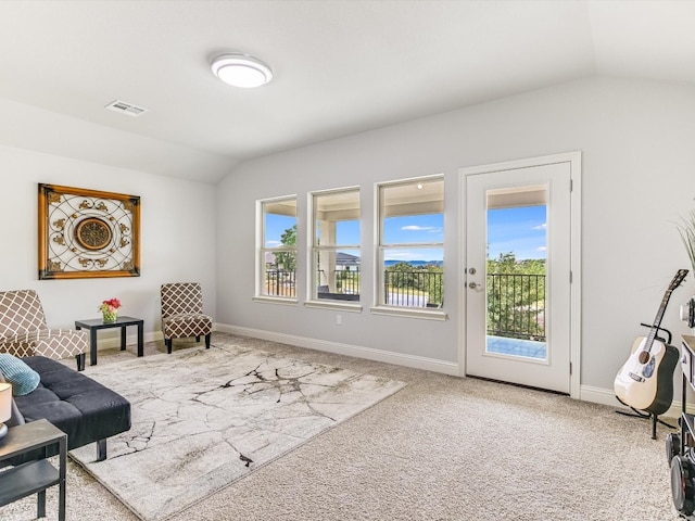 sitting room featuring lofted ceiling, plenty of natural light, and light carpet