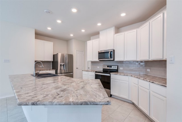 kitchen with backsplash, stainless steel appliances, white cabinetry, and sink