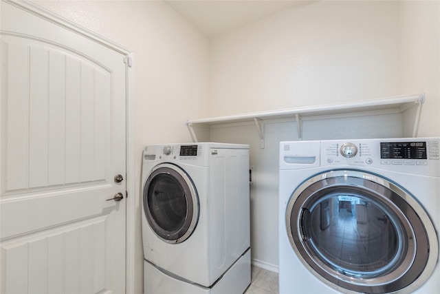 laundry room with light tile patterned flooring and washer and dryer