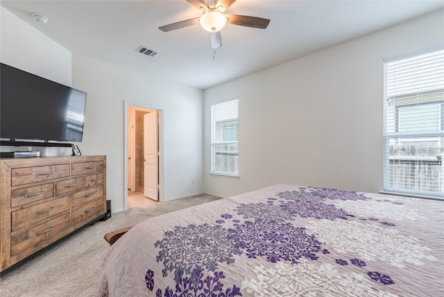 carpeted bedroom with ceiling fan and connected bathroom