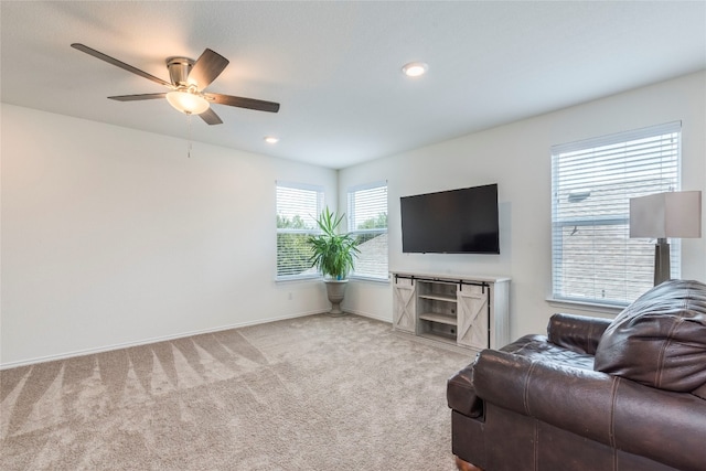 carpeted living room with ceiling fan