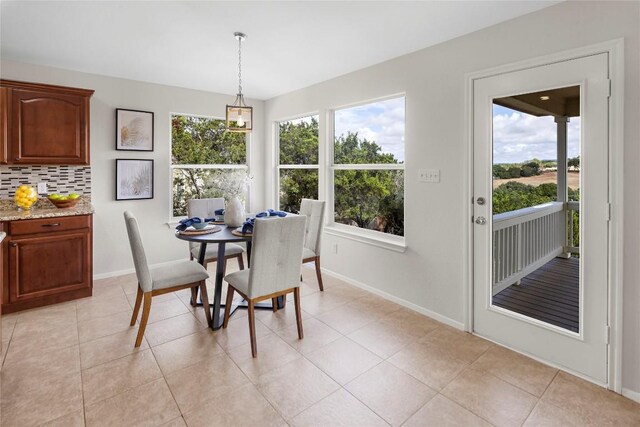 dining area featuring light tile patterned floors, plenty of natural light, and baseboards